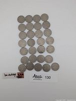 Front view of 29 Canadian nickel coins arranged in rows