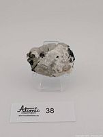 Front view of green tourmaline specimen on acrylic stand