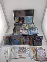 Overall lot with metal tin, stacks of cards, holographic fronts visible