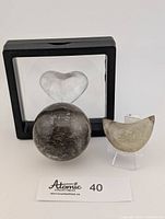 Sphere, crescent moon, heart and two holders displayed together