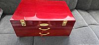 Closed red wooden chest with brass latches