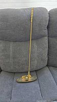 Full view of brass golf club ornament on couch