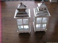 Front view of both white lanterns showing metal roofs and glass panels
