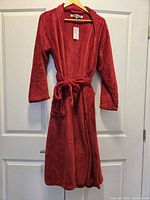Front view of red fleece bathrobe on hanger, belt tied