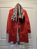 Front of red Cleo coat with patterned scarf hanging over collar