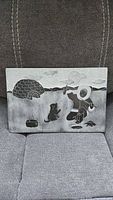 Front view of etched soapstone plaque showing full Inuit fishing scene