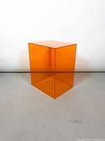 Front view of orange acrylic side table