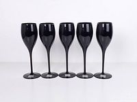 Front view of five black crystal goblets standing in a row