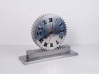 Front view of metal gear mantel clock showing Roman numerals and hands