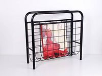 Front view of black tubular steel magazine holder with magazine for scale