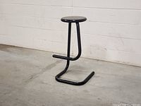 Front angle of black metal paperclip stool