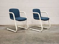 Front angled view of both cantilever chairs showing design and condition