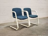 Front angled view of both chairs showing upholstery color and cantilever frames