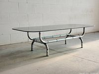 Side view showing full table with smoked glass top and chrome bamboo-style base