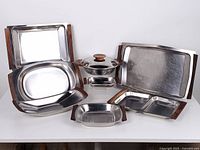 All eight stainless steel serving pieces displayed