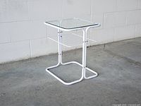 Full view of side table showing frame, glass top, and magazine rack