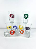 Seven glasses stacked showing various billiard numbers and two lying down