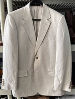 Front view of blazer on hanger showing color, lapel, buttons, pockets