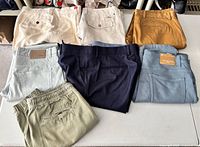 Seven pairs of men’s pants laid out showing colours and styles