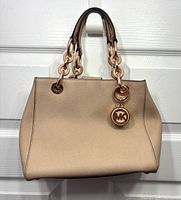 Front view of beige Michael Kors Cynthia satchel showing shape and handles