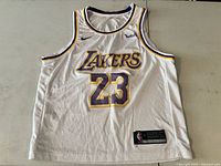 Front view of white Lakers #23 jersey showing logos and size tag
