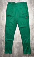 Front view of green OVO track pants showing owl logo and overall condition