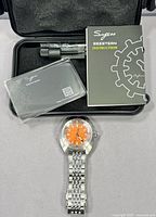 Watch set in case with booklet, card, tool