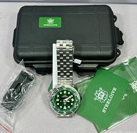 Watch with bracelet, hard case, spare strap, cards visible