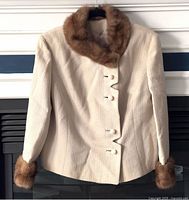 Front view of beige wool blazer with fur collar and cuffs