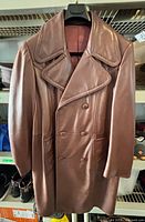 front view of brown double-breasted leather jacket on hanger