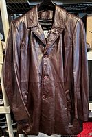 Front view of burgundy leather jacket hanging