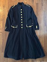 Front view of black Mondi wool/cashmere military coat with gold buttons and trim