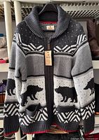 Front view of cardigan on hanger showing bear motif, full zip, pockets