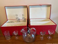 Overall lot with two red boxes, pitcher, coupes on table