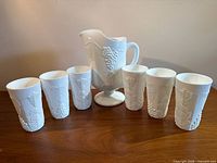 Pitcher and six tumblers arranged on table