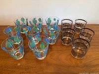 Seven balloon motif glasses and five striped glasses on wood surface