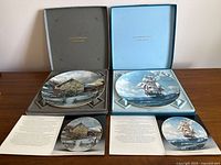 Both plates in open presentation boxes with paperwork