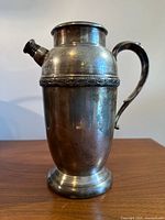 Side view of silver-plated cocktail shaker with handle