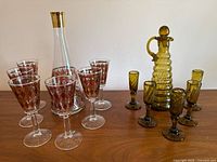 Both decanter sets side by side on wooden surface