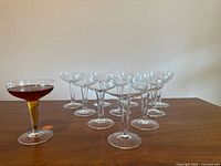 Front view of all 11 coupe glasses, one filled to show shape
