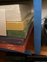 Stack showing two white reams on top of yellow, green, purple, red reams