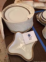 Stack of dinner plates in quilted storage case with matching relish dish displaying rim pattern