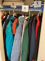 Full view of closet rail with multiple jackets under lot tag