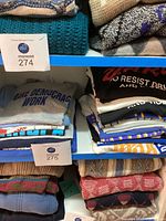 Stack of folded men’s T-shirts showing grey "Make Democracy Work" graphic and other shirts beneath