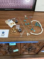 Overview of assorted jewellery pieces laid out on dresser