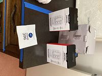 Two retail boxes of One Power 6-outlet swivel surge protectors beside open carton containing white power tower