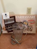 Grouped lot showing Farberware 64-piece flatware box, glass vase, oval tray and casserole stand