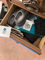 Drawer view showing slippers, scarves, gloves and necklace
