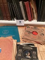 Shelf with leather-spined opera LP volumes, stacks of records below