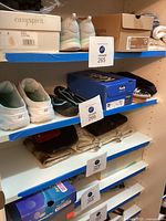 Shelf view showing multiple pairs: water shoes, sneakers, slippers, boxes